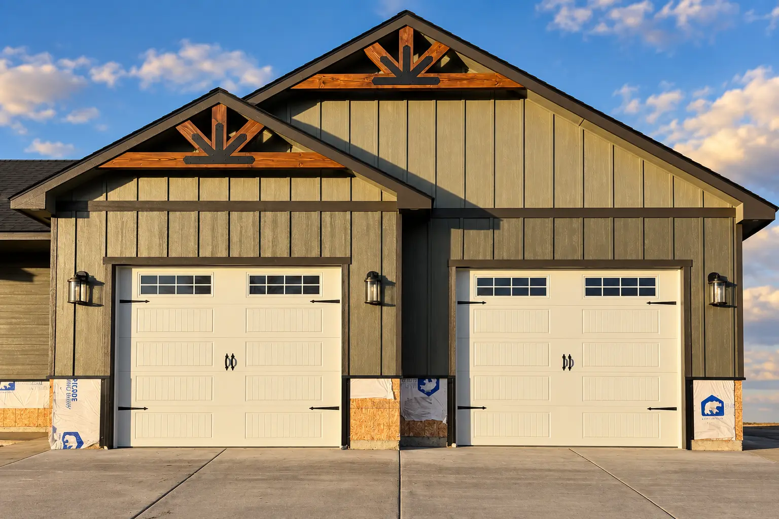 White carriage-style garage doors installed on a Craftsman home